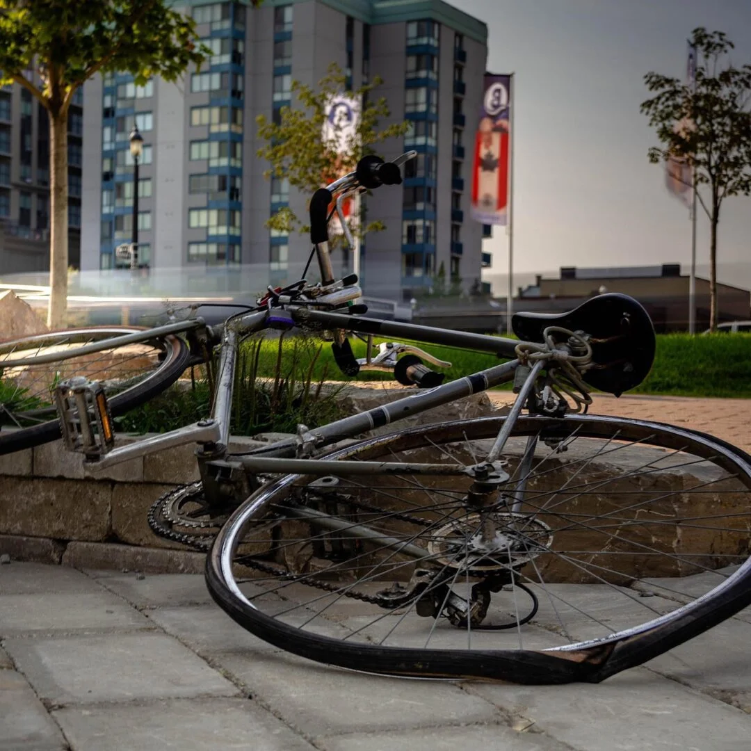 A bicycle laying on the ground in front of buildings.