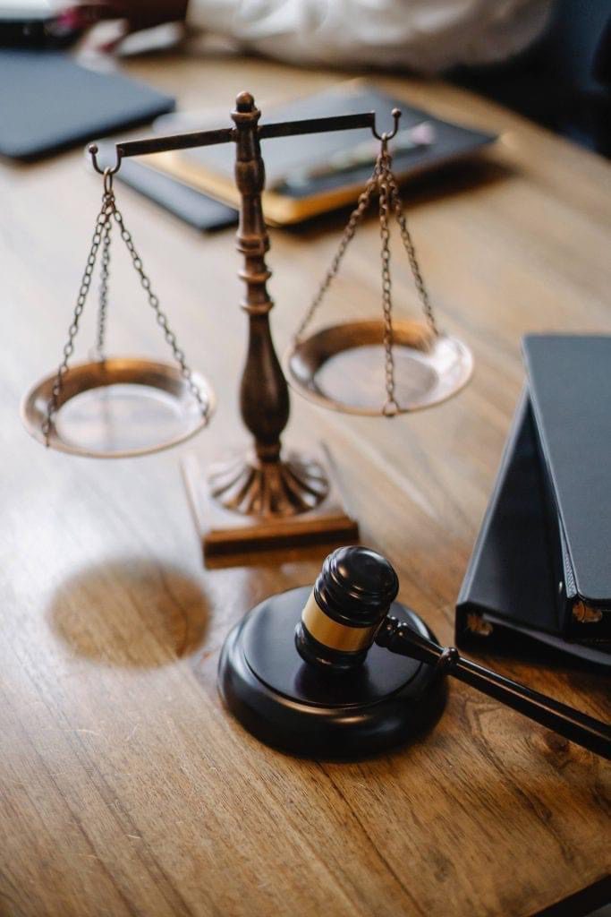 A judge 's gavel and scale on top of a table.