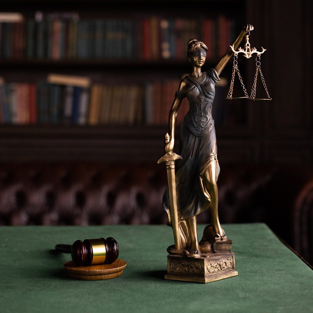 A statue of lady justice and a judge 's gavel on the table.
