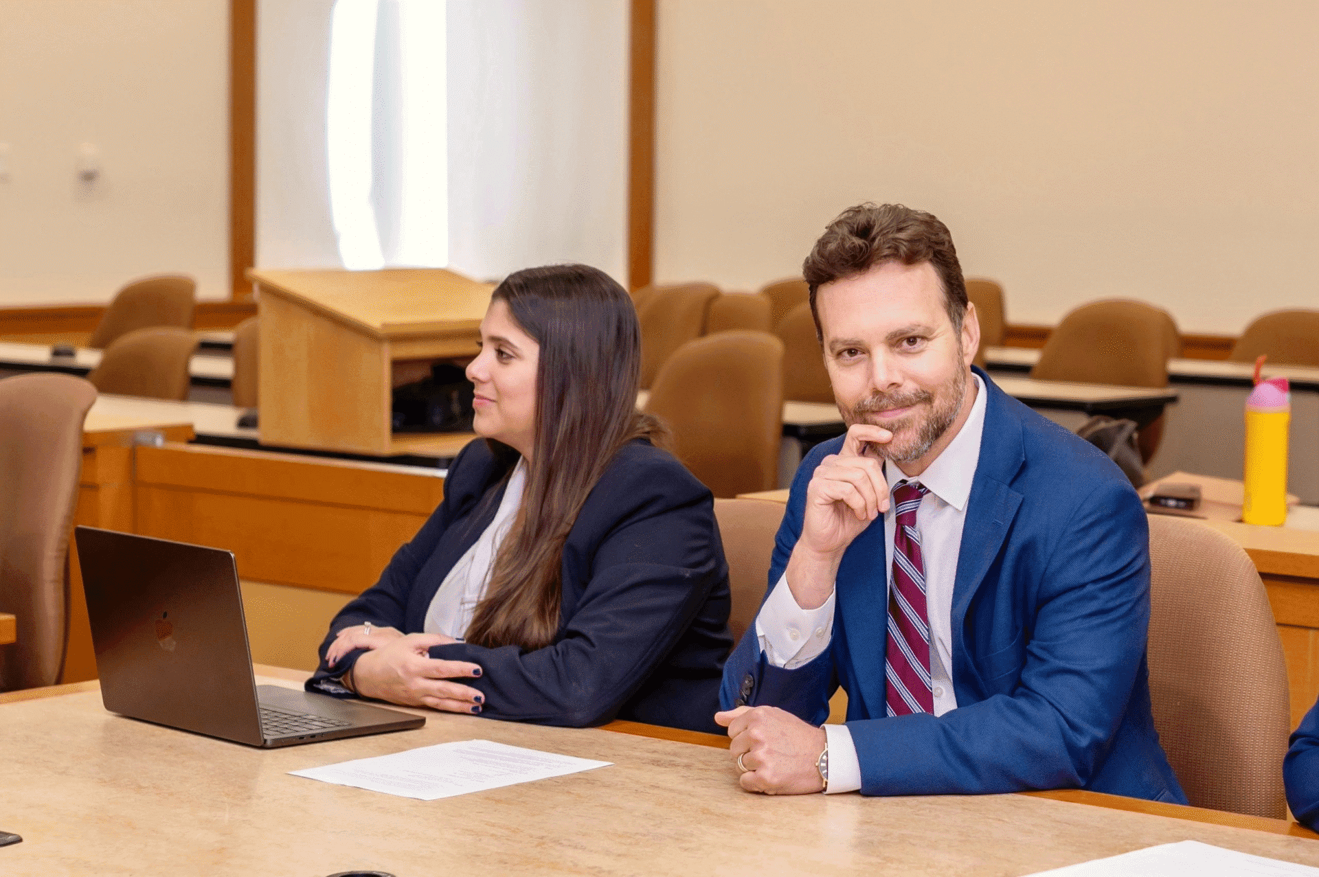 Two people sitting in a meeting room.